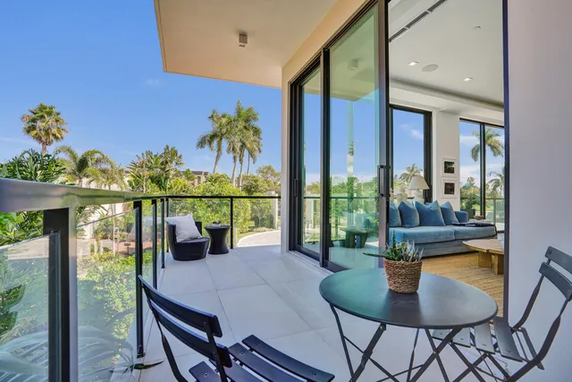 a view of a balcony and dining table with chairs