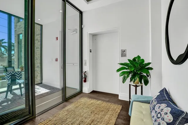 a view of a hallway with paintings on the floor and a potted plant