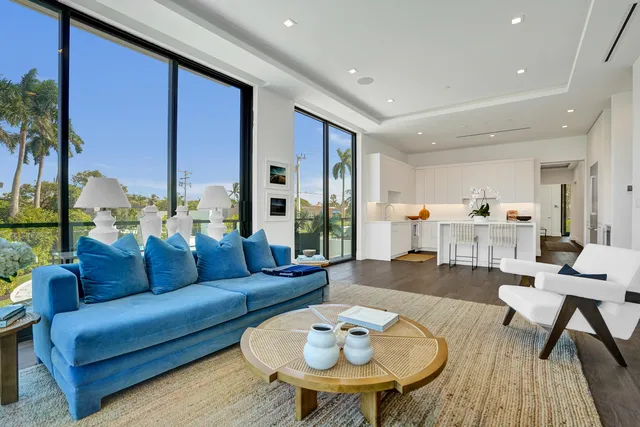 a living room with furniture kitchen view and a large window