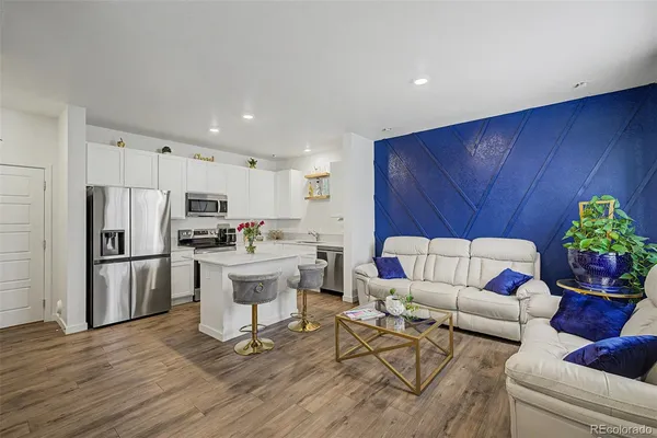 a living room with kitchen island furniture and a kitchen view