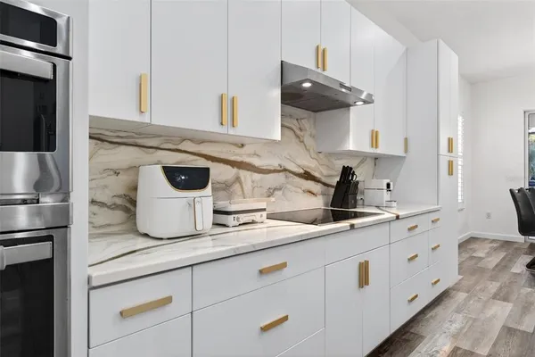 a kitchen with counter top space a sink cabinets and stainless steel appliances