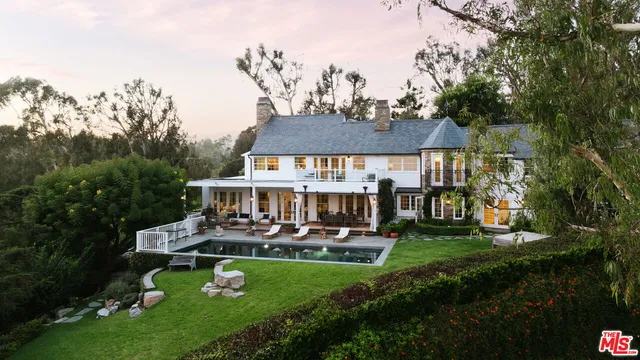 an aerial view of a house with swimming pool garden and patio
