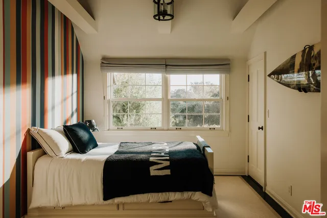 a bedroom with bed and windows