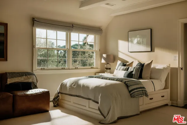 a bedroom with bed couch and window