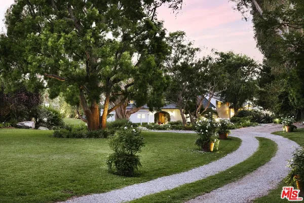 a front view of a house with yard swimming pool and outdoor seating