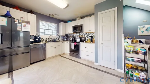 a kitchen with stainless steel appliances granite countertop a refrigerator and a sink