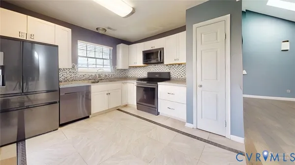 a kitchen with granite countertop a stove a refrigerator and cabinets