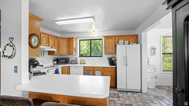 335 Jungfrau Hill Road Midway, UT 84049 - Photo 19 of 34 Kitchen with light countertops, white appliances, a peninsula, and wood finish cabinets