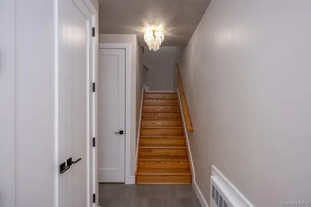 a view of a hallway with wooden floor and entryway