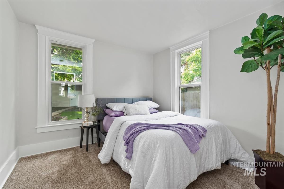 910 North 16th Street Boise, ID 83702 - Photo 14 of 47 Bedroom featuring plush carpet flooring, two double-hung windows with white trim, and light-colored walls