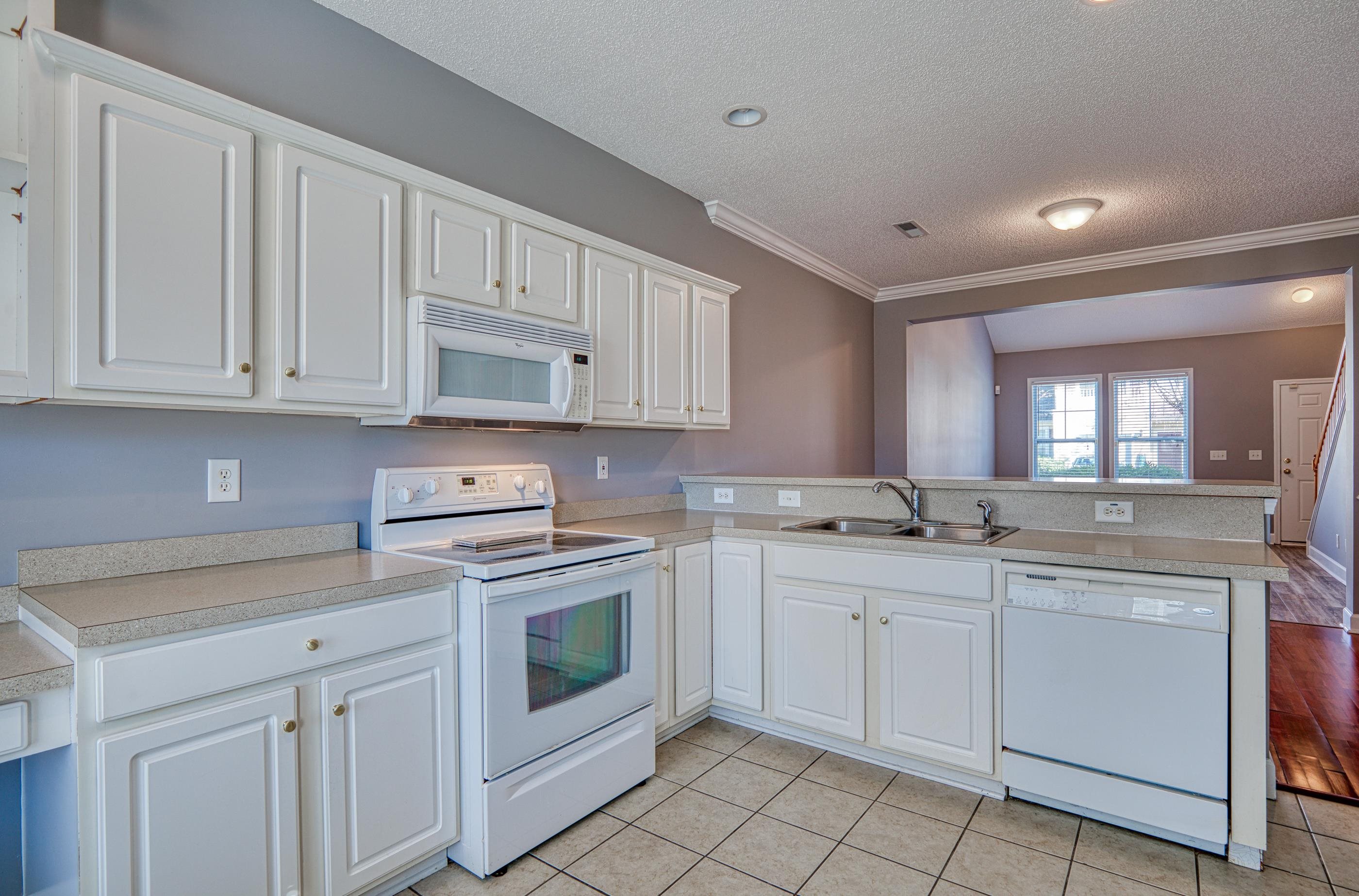 205 Threshing Way, Unit 1050 Myrtle Beach, SC 29579 - Photo 13 of 40 Kitchen with white appliances, light countertops, white cabinetry, a peninsula, and a textured ceiling