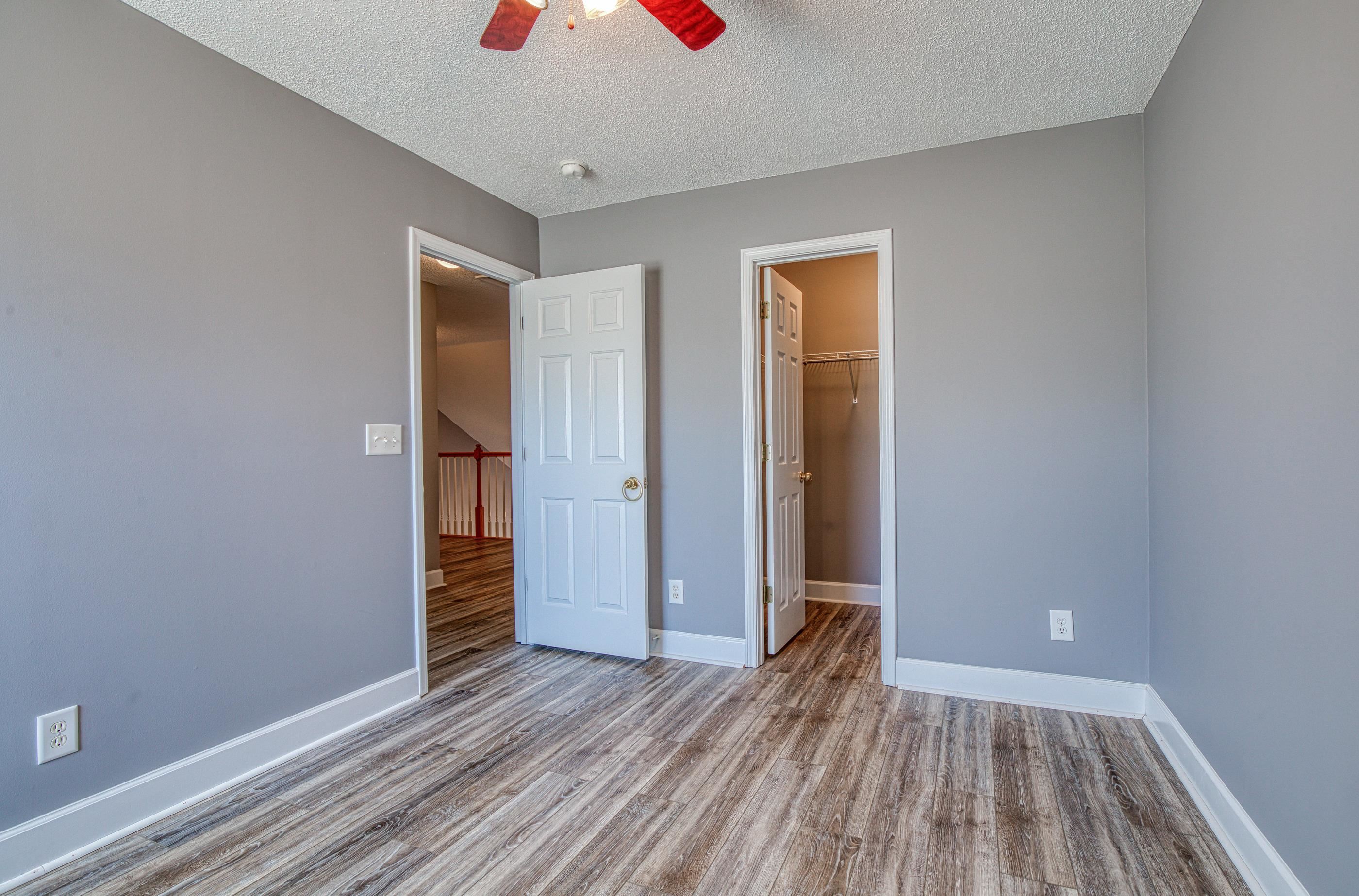 205 Threshing Way, Unit 1050 Myrtle Beach, SC 29579 - Photo 32 of 40 Unfurnished bedroom with a textured ceiling, a walk in closet, wood finished floors, and a ceiling fan