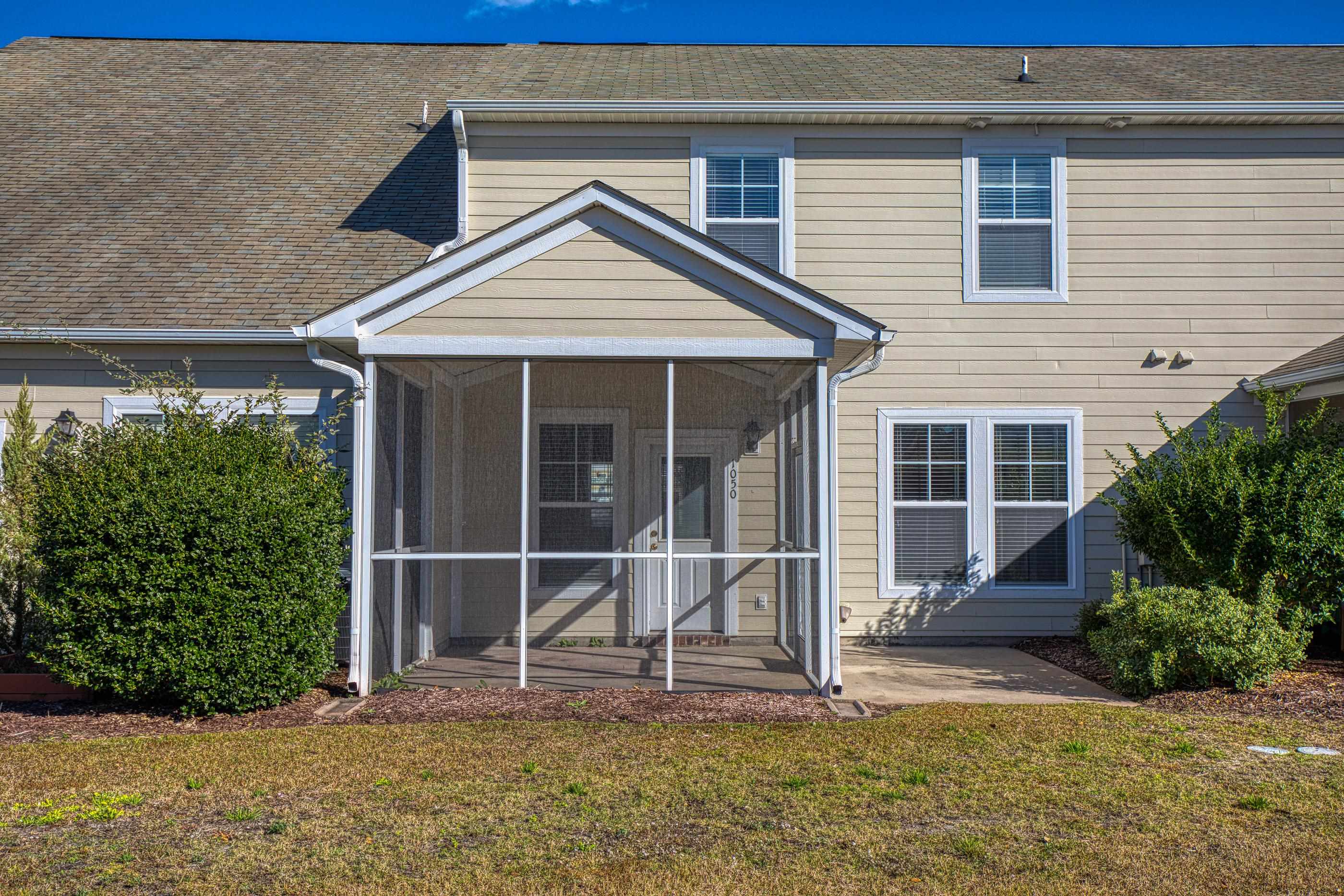 205 Threshing Way, Unit 1050 Myrtle Beach, SC 29579 - Photo 37 of 40 Rear view of house with roof with shingles, a sunroom, and a lawn
