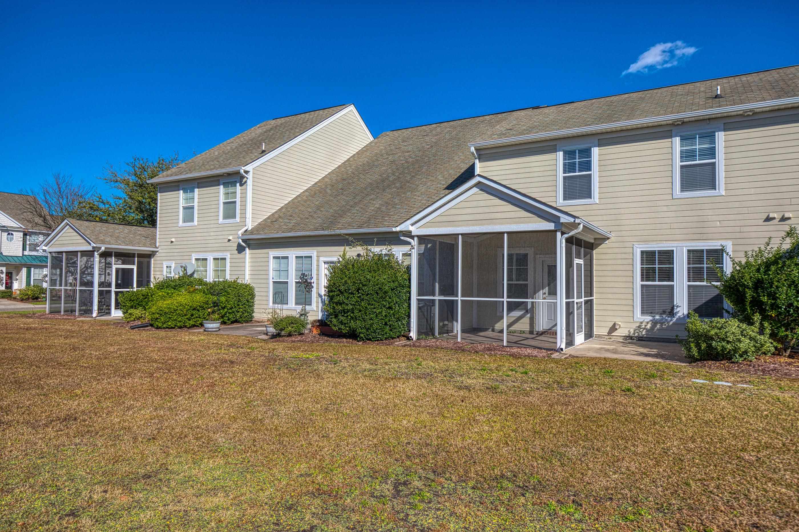 205 Threshing Way, Unit 1050 Myrtle Beach, SC 29579 - Photo 38 of 40 Back of house featuring a lawn, a sunroom, and a shingled roof