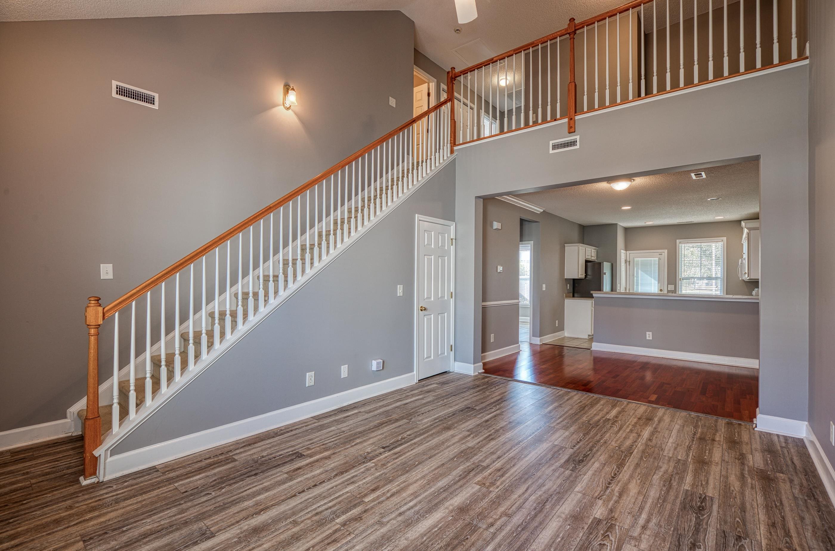 205 Threshing Way, Unit 1050 Myrtle Beach, SC 29579 - Photo 5 of 40 Unfurnished living room with dark wood finished floors, high vaulted ceiling, stairway, and a ceiling fan