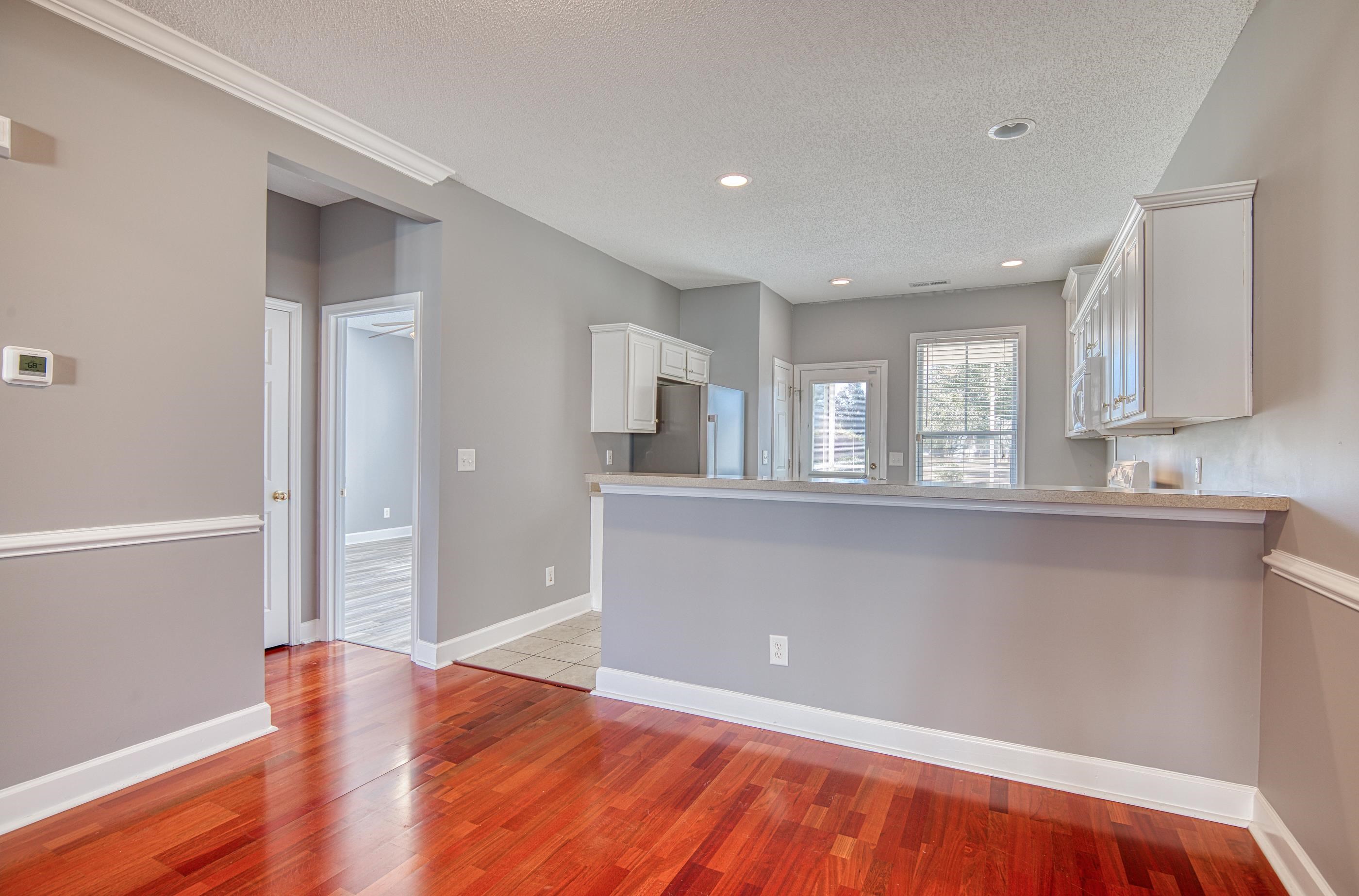 205 Threshing Way, Unit 1050 Myrtle Beach, SC 29579 - Photo 9 of 40 Kitchen featuring white cabinetry, a textured ceiling, light countertops, a peninsula, and freestanding refrigerator