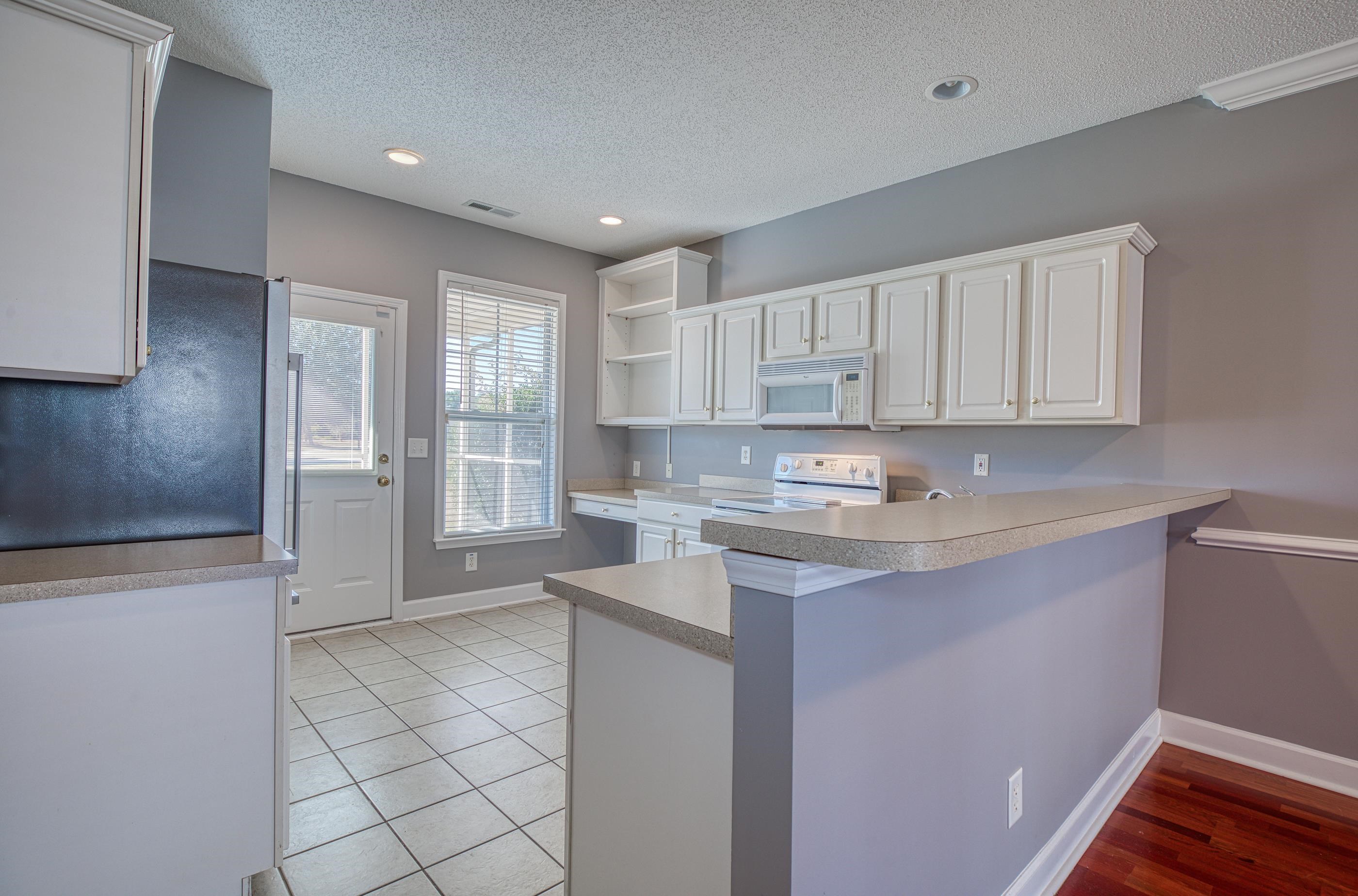 205 Threshing Way, Unit 1050 Myrtle Beach, SC 29579 - Photo 10 of 40 Kitchen with white cabinets, a textured ceiling, white appliances, light countertops, and a peninsula