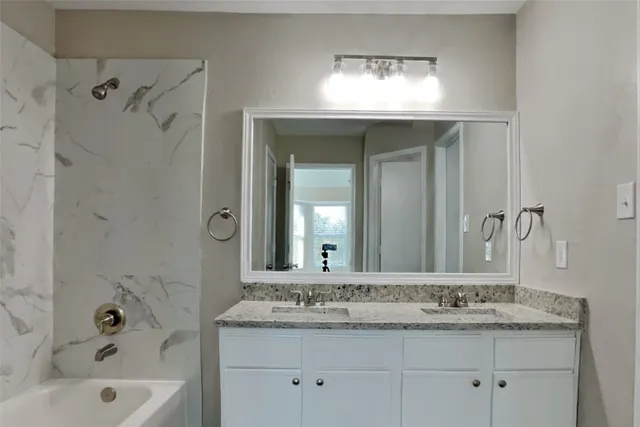 a bathroom with a granite countertop sink and a mirror