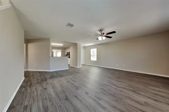 a view of a livingroom with wooden floor and a ceiling fan