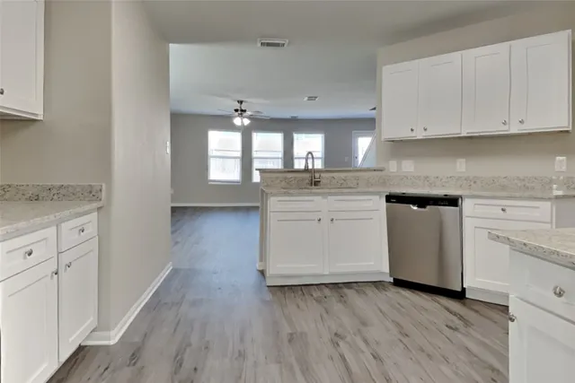 a kitchen with granite countertop white cabinets and white appliances