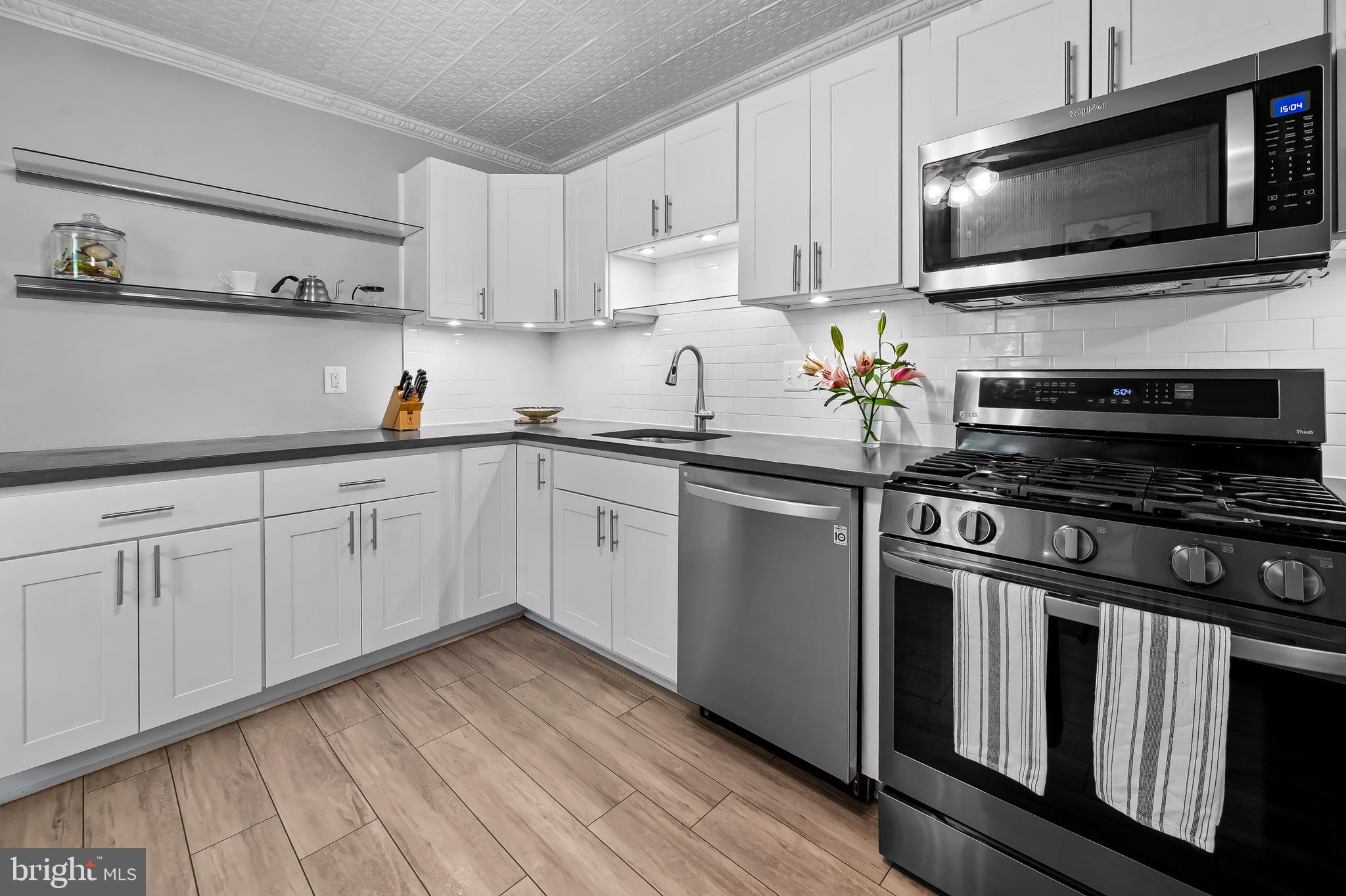 4605 Schenley Road Baltimore, MD 21210 - Photo 13 of 44 a kitchen with cabinets stainless steel appliances and wooden floor