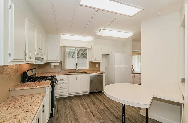 a kitchen with a stove a sink and a refrigerator