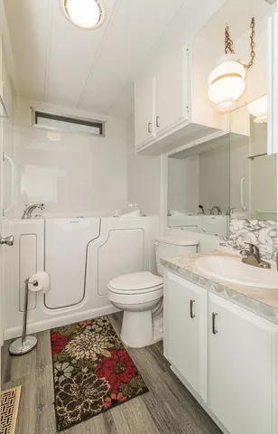 a kitchen with stainless steel appliances a white cabinets and wooden floor