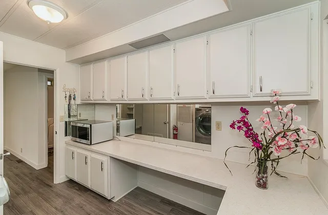 a kitchen with stainless steel appliances a white cabinets and wooden floor