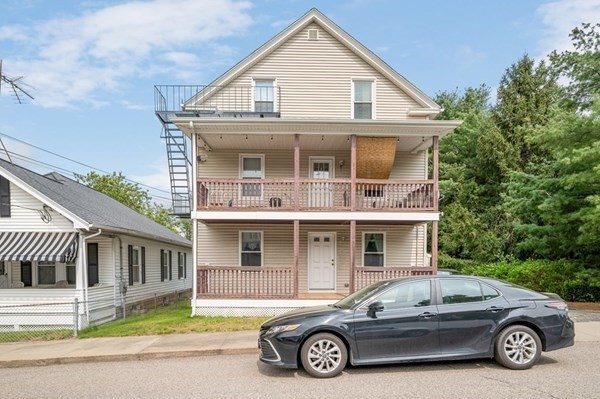 a car parked in front of a white house