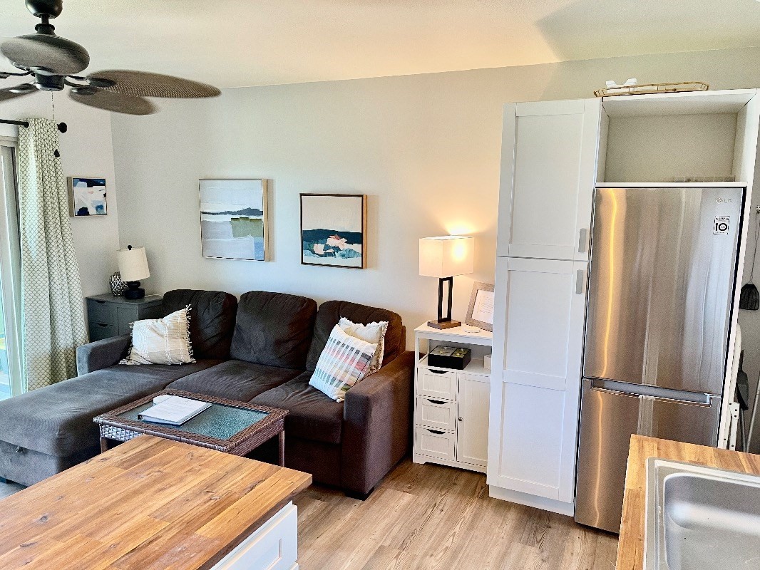 95-788 Ninole Loop Road, Unit 41 Naalehu, HI 96772 - Photo 4 of 19 a living room with furniture and a refrigerator