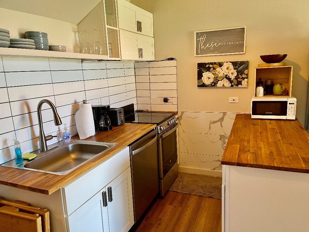 95-788 Ninole Loop Road, Unit 41 Naalehu, HI 96772 - Photo 7 of 19 a kitchen with stainless steel appliances granite countertop a sink and a stove