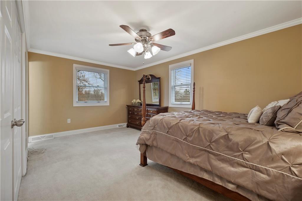 1787 Hassam Road Coraopolis, PA 15108 - Photo 15 of 28 The large primary bedroom offers lots of space and includes a ceiling fan light and crown molding.
