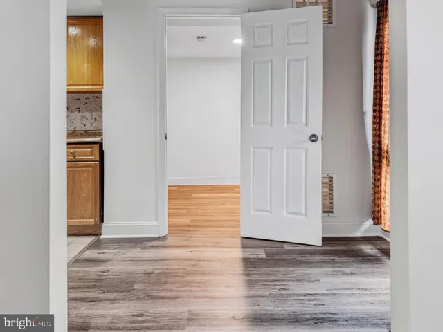 a view of an empty room with wooden floor and closet