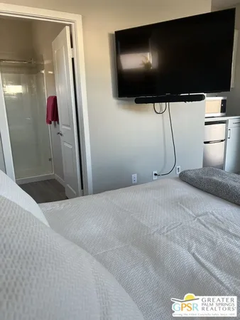 a bedroom with a bed and a flat screen tv