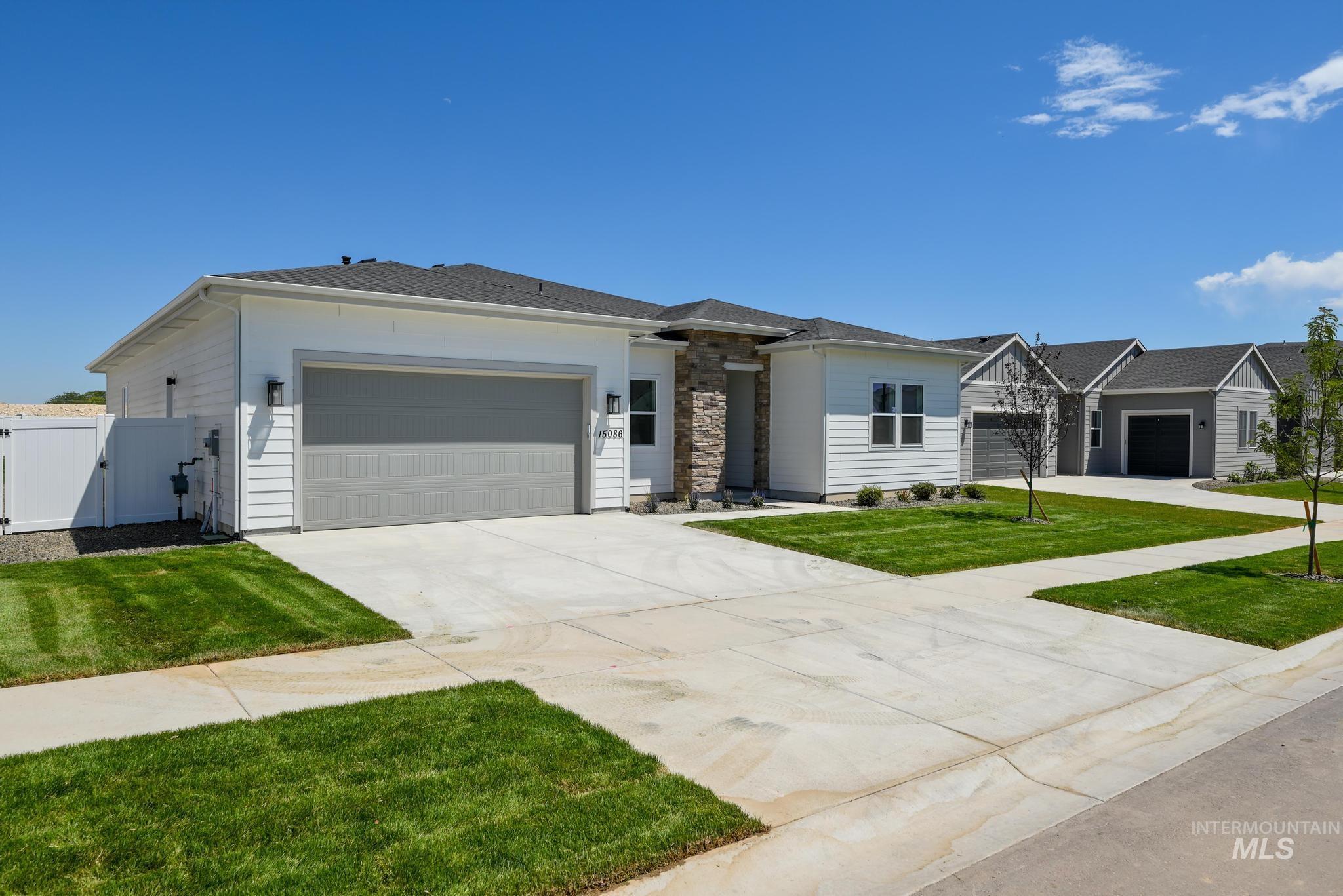 15086 Steel Cloud Avenue Caldwell, ID 83607 - Photo 2 of 41 View of front facade with a gate, a garage, driveway, and stone siding