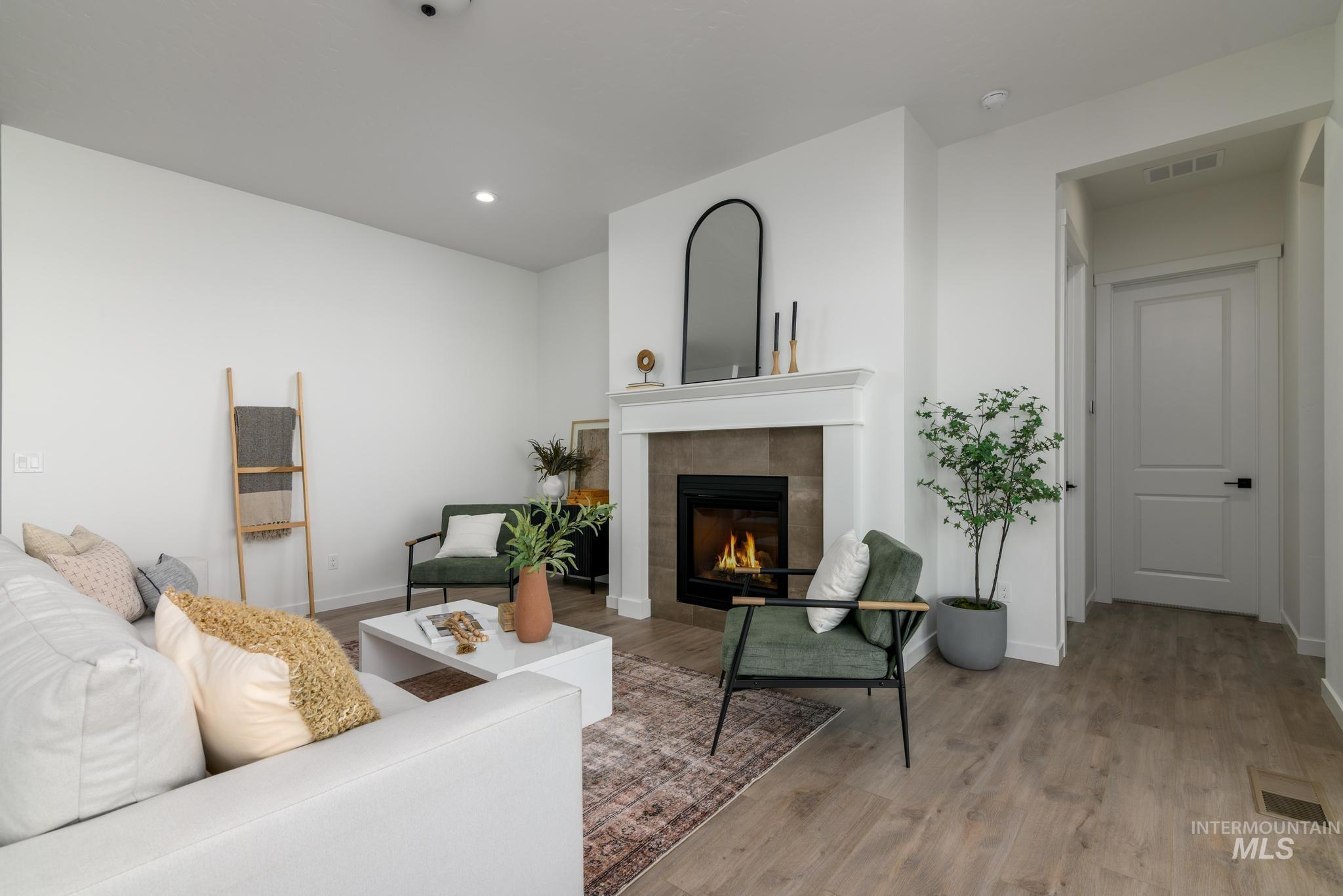15086 Steel Cloud Avenue Caldwell, ID 83607 - Photo 6 of 41 Living room featuring light wood-style floors, a tile fireplace, and recessed lighting