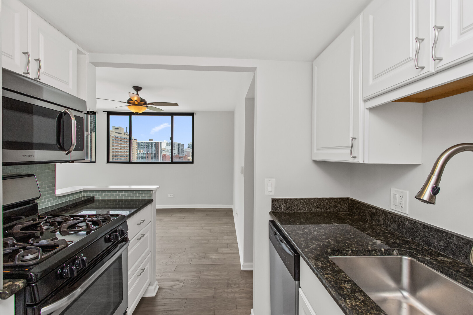 6150 North Kenmore Avenue, Unit 15B Chicago, IL 60660 - Photo 11 of 26 a kitchen with stainless steel appliances granite countertop a sink stove and microwave