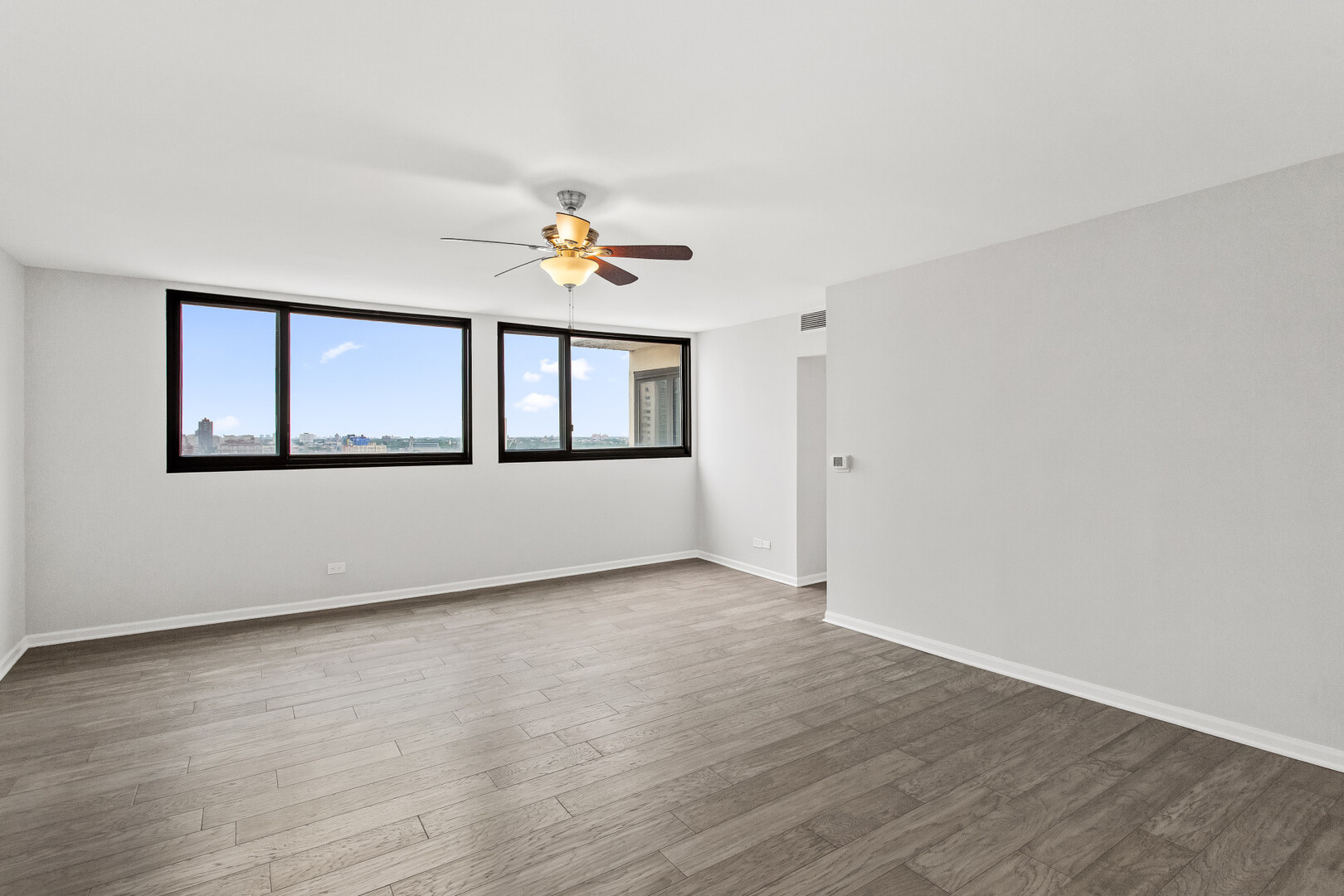 6150 North Kenmore Avenue, Unit 15B Chicago, IL 60660 - Photo 12 of 26 an empty room with wooden floor and windows