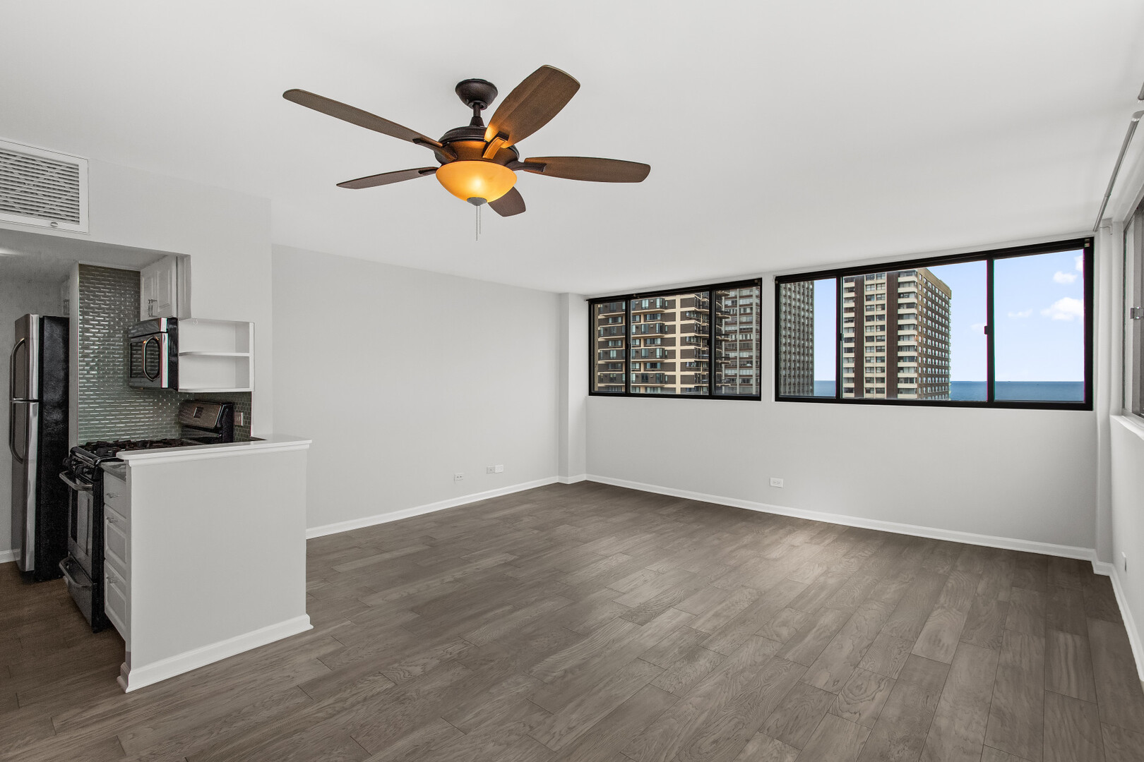 6150 North Kenmore Avenue, Unit 15B Chicago, IL 60660 - Photo 5 of 26 a view of a livingroom with a hardwood floor and a ceiling fan