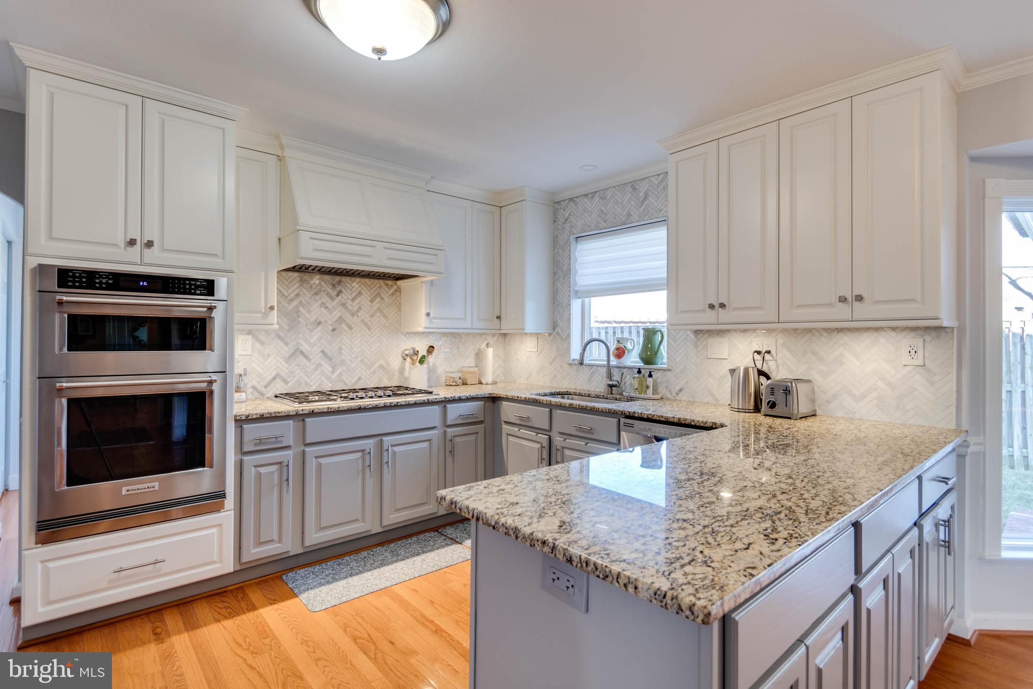 1007 St Stephens Road Alexandria, VA 22304 - Photo 17 of 59 a kitchen with stainless steel appliances granite countertop a kitchen island hardwood floor sink and stove