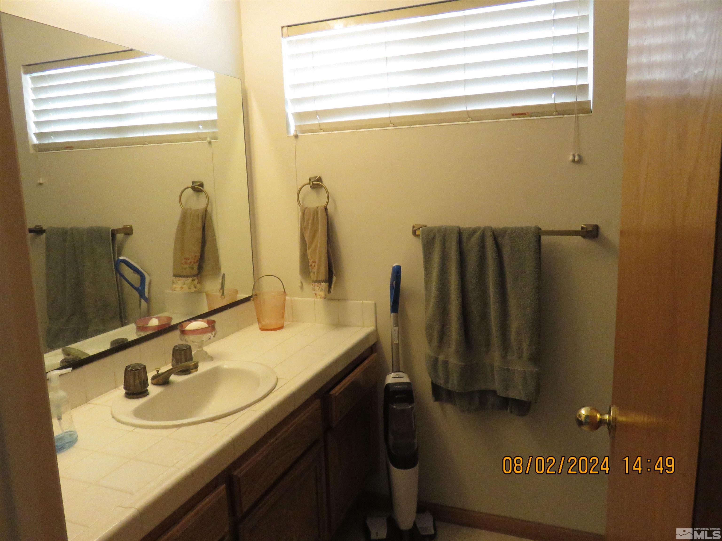 7131 Lighthouse Lane Reno, NV 89511 - Photo 7 of 11 a bathroom with a sink and a mirror