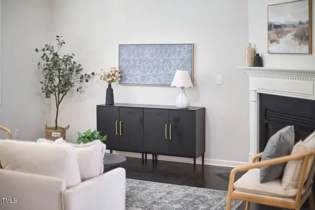 a living room with furniture a fireplace and a chandelier