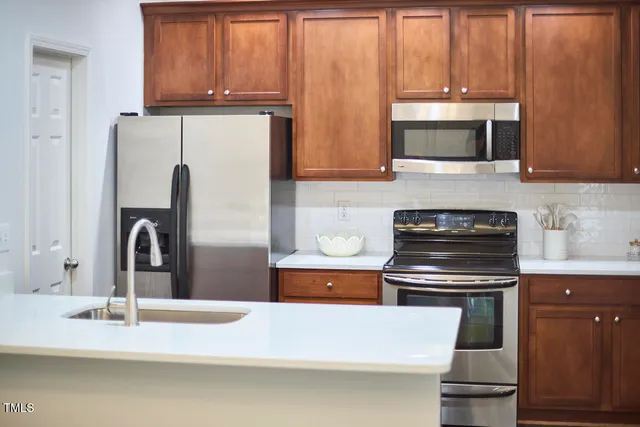 a dining room with wooden floor a chandelier a glass table and chairs