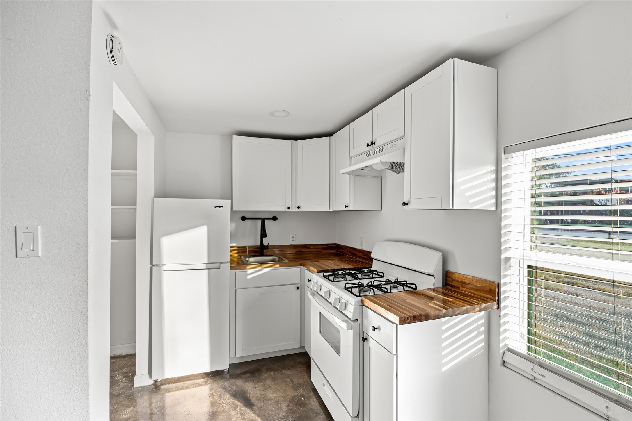 7303 Market Street Houston, TX 77020 - Photo 8 of 18 a kitchen with cabinets appliances a sink and a window