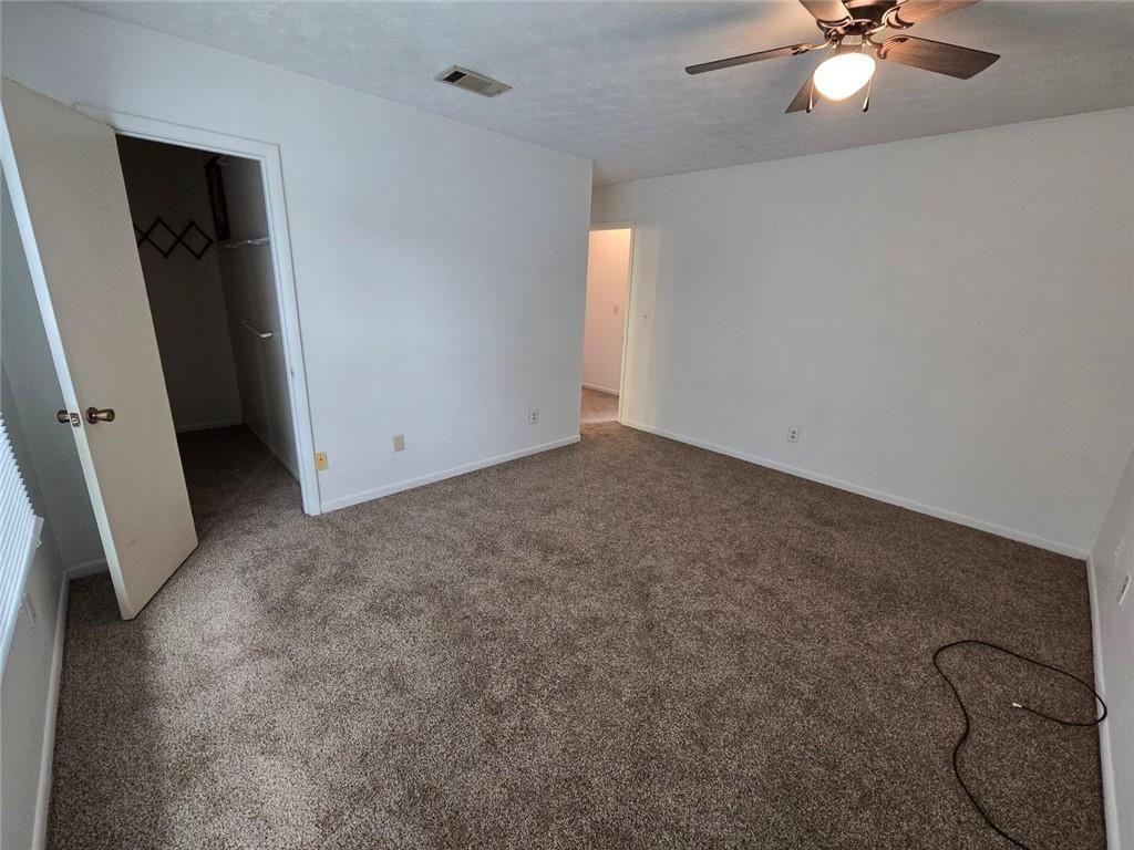 1297 Tree Creek Court Clarkston, GA 30021 - Photo 24 of 31 an empty room with windows and fan