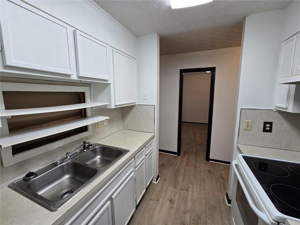 1297 Tree Creek Court Clarkston, GA 30021 - Photo 3 of 31 a kitchen with a sink and white cabinets