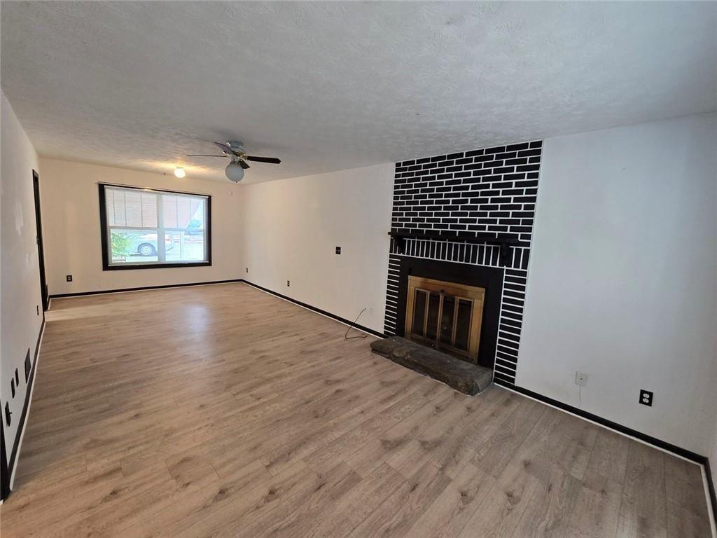1297 Tree Creek Court Clarkston, GA 30021 - Photo 9 of 31 an empty room with wooden floor fireplace and windows