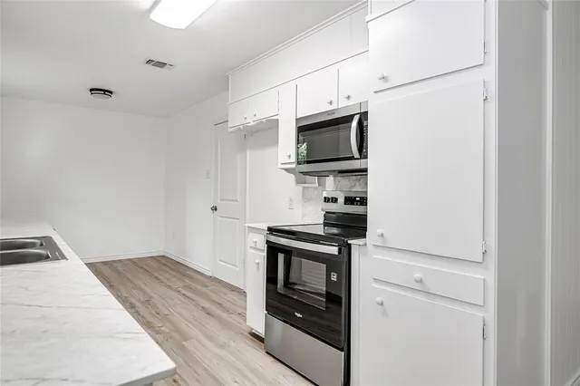 a kitchen with stainless steel appliances a stove microwave and refrigerator