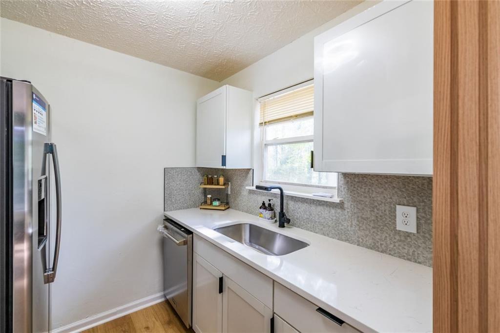 3493 Newberry Trail Decatur, GA 30034 - Photo 18 of 48 a kitchen with stainless steel appliances granite countertop a sink a refrigerator and a window