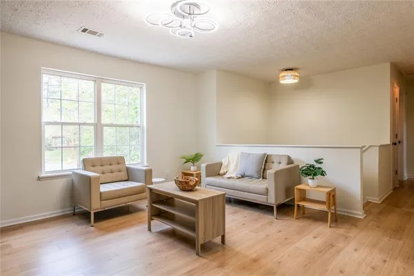 a living room with furniture kitchen view and a window